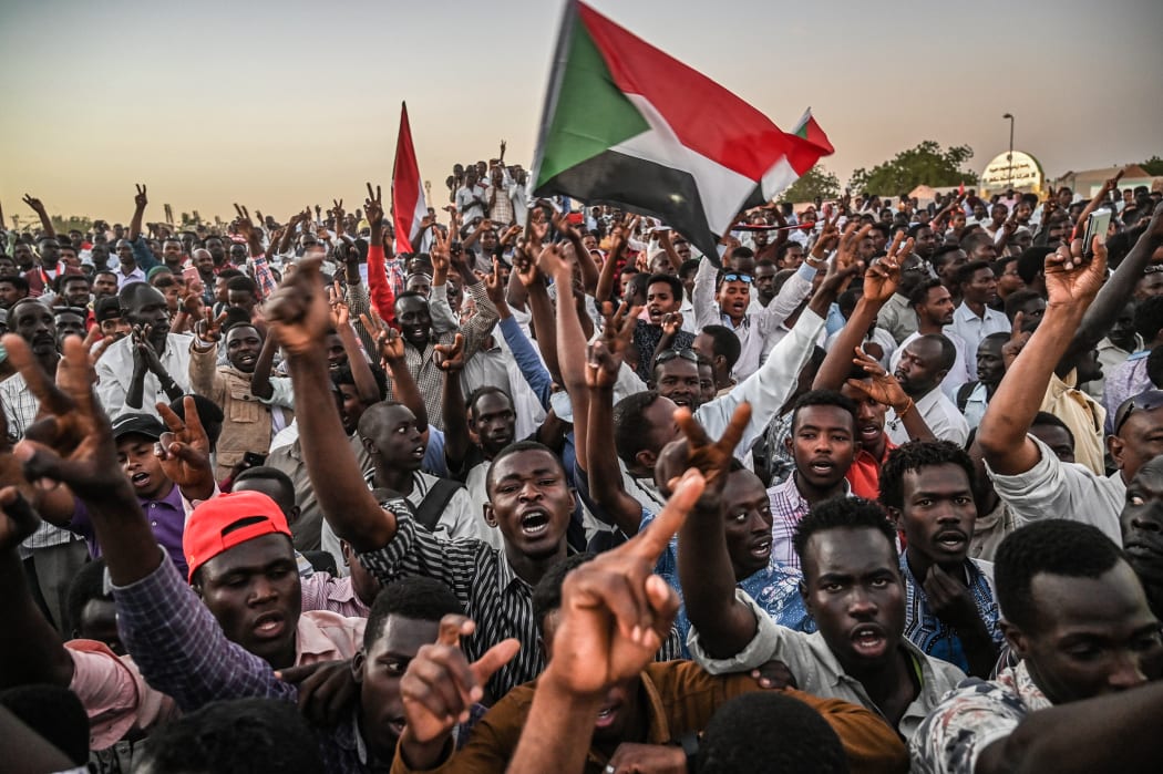 Sudanese protesters gather as they shout slogans and wawe national flags during a protest outside the army headquarters in the capital Khartoum on April 21, 2019.